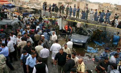 Agentes de seguridad y civiles se agolpan en el lugar de la explosión de un coche bomba cerca de la entrada del cementerio Wadi Al-Salam de Nayaf (Sur de Bagdad).