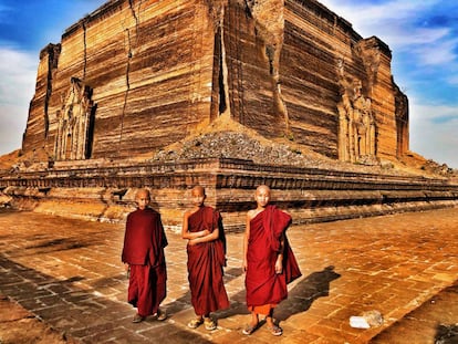 Tres novicios budistas posan ante Mingun Paya, la pagoda inacabada.