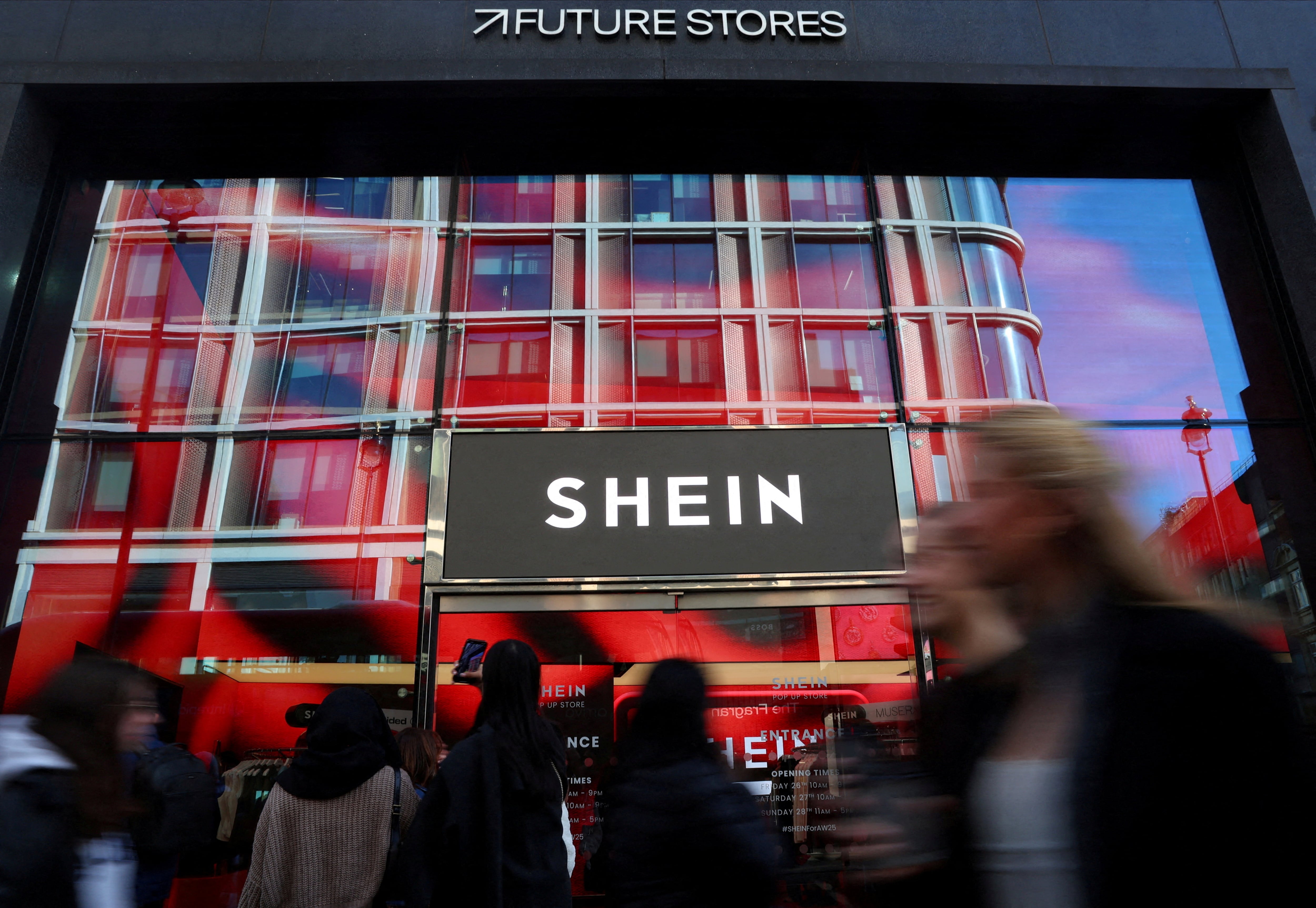 La gente pasa junto a la tienda temporal de Shein