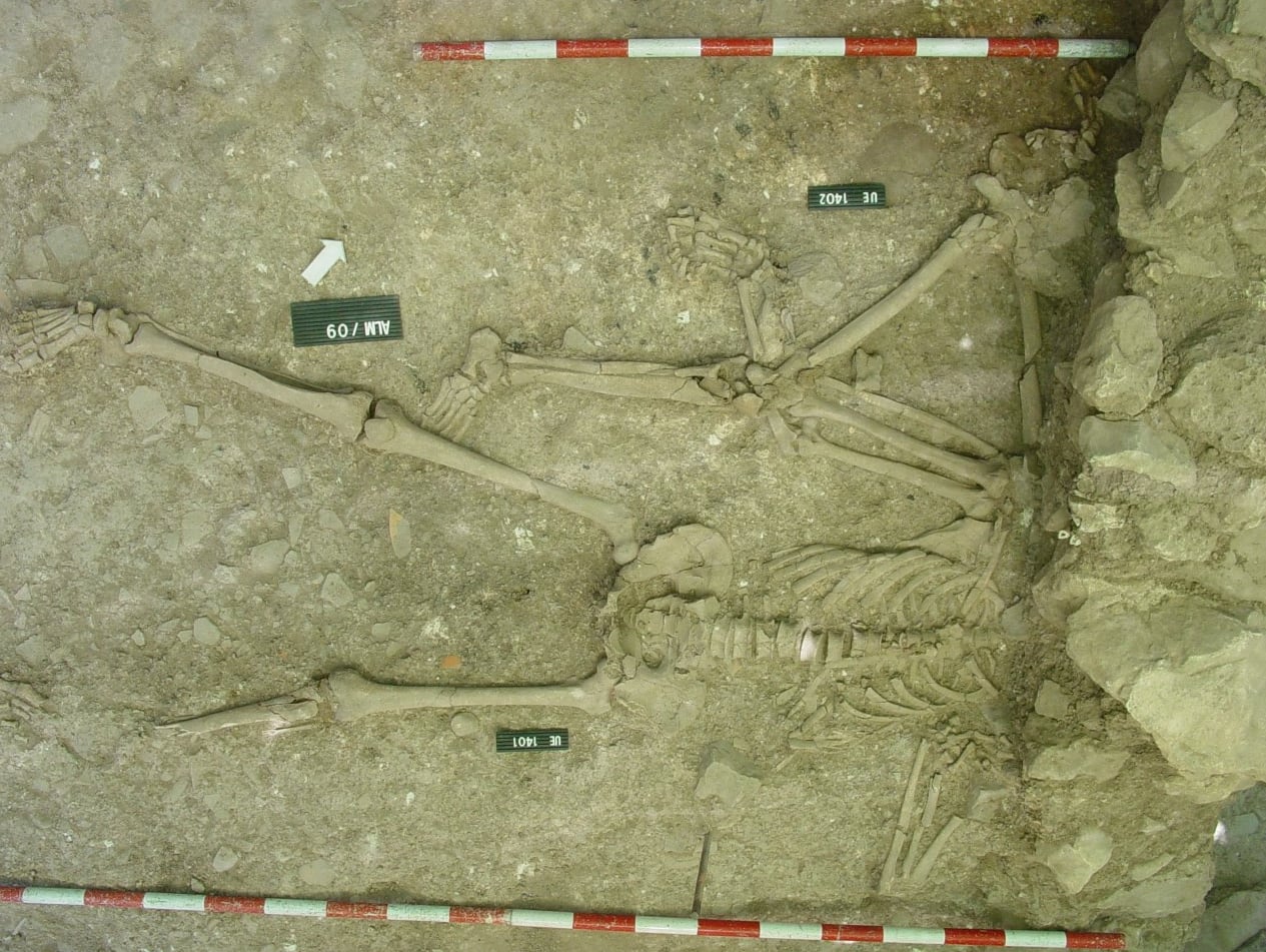 Dos de los cuerpos hallados en el yacimiento de Almedilla (Córdoba), aplastados por el derrumbe de un muro.