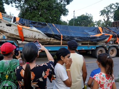 La gente mira el bote en el que unos pescadores encontraron cuerpos descompuestos, mientras lo remolcan en Pará, Brasil, el 15 de abril.