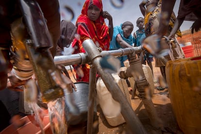 Refugiados sudaneses recogen agua de un pozo en el campamento de Adré (Chad), en la frontera con Sudán. 