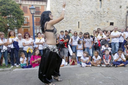 Una joven baila la danza del vientre en el mercado medieval de Portugalete.