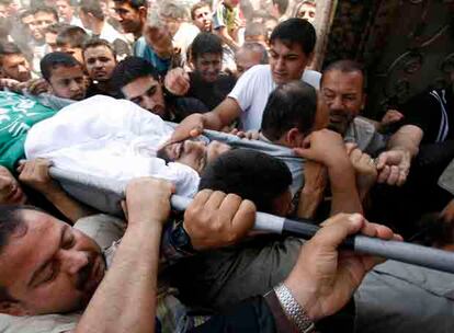 Un miliciano de Hamas muerto esta mañana es transportado en camilla entre una multitud.