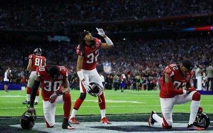 Jugadores de los Atlanta Falcons rezan antes del partido.