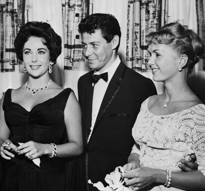 Cuando Liz Taylor se quedó viuda de Mike Todd, el mejor amigo de éste, el cantante Eddie Fisher, se pasó de la raya consolándola y acabó acostándose con ella. Poco después, Fisher dejó a su mujer, la famosa Debbie Reynolds, para irse con Taylor, en uno de los escándalos más explosivos de los años 50. La prensa del corazón conservadora le echó la culpa a Taylor por “romper hogares”, ya que la pareja tenía una hija de dos años, Carrie Fisher, futura princesa Leia de 'Star Wars'. Otros arremetieron contra Eddie y le atacaron hasta acabar con su prestigio como cantante. Total, para que dos años después Taylor lo dejara por Richard Burton. En la imagen, Eddie Fisher con su mujer Debbie Reynolds (derecha) y Elizabeth Taylor, en el Tropicana Hotel en 1958.