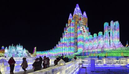 Visitantes ante una de las esculturas de hielo construídas durante el festival internacional de Harbin.