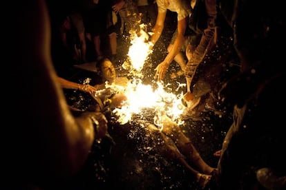 Varias personas intentan apagar las llamas del manifestante que se prendió fuego.