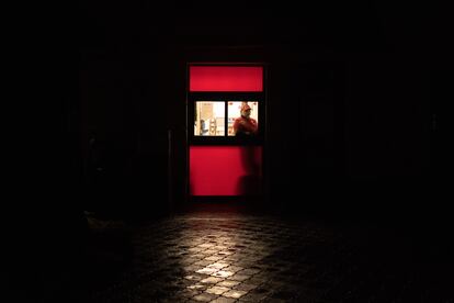 Una trabajadora de un restaurante del barrio de Podil, en el centro de Kiev, esperaba la noche del domingo la llegada de los clientes mientras las calles permanecían oscuras por los cortes de energía como medida de reacción ante los ataques rusos a las centrales eléctricas ucranias.