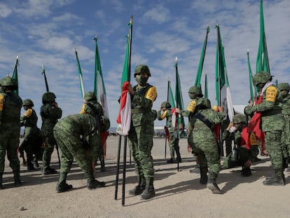 Elementos del Ejército Mexicano sostienen banderas durante la ceremonia de conmemoración de los 109 años de la institución, en febrero.