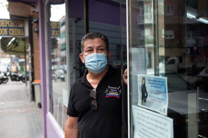 Tony Gutiérrez, dueño de dos peluquerías Anticrisis, en la puerta de su local en la calle Vicente Espinel, al sur de la calle Alcalá de Madrid.