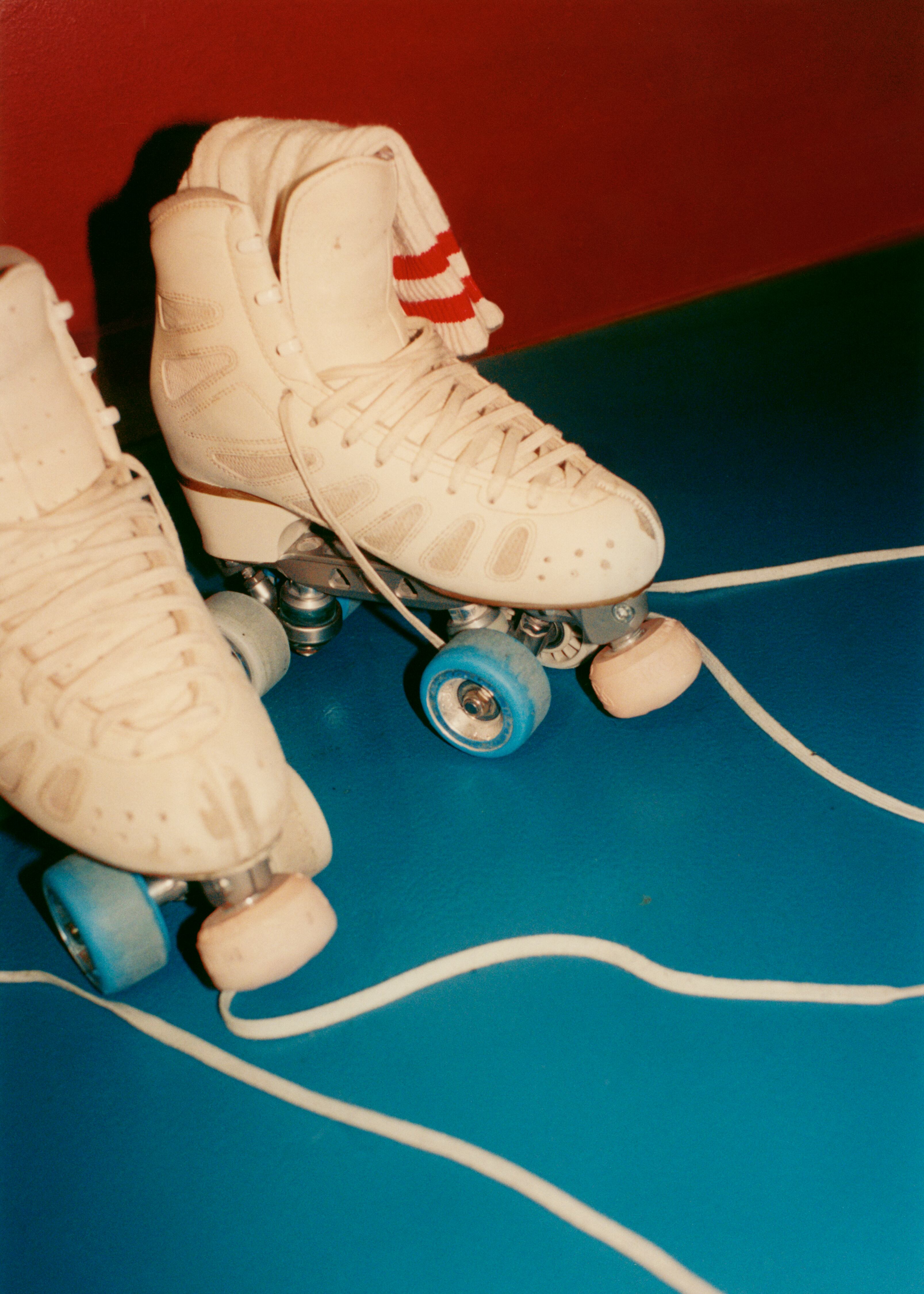De los patines asoman calcetines de American Apparel.