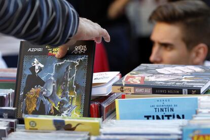 Un transeúnte echa un vistazo a un libro de ilustración de Azpiri y Forges en la plaza de Callao, donde más de 40 librerías colocaron sus expositores durante todo el día con su mejor oferta bibliográfica. Los cómics también estuvieron presentes en puestos como el de La Marabunta.