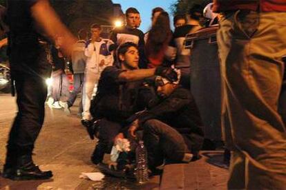 Un policía nacional atiende a Víctor, el fotógrafo del periódico<i> Latino</i>, que fue apaleado en Villaverde.