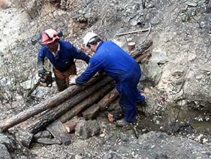 Dos vecinos de Berrocal, ayer, durante la preparación de una albarrada en la Pata del Caballo.