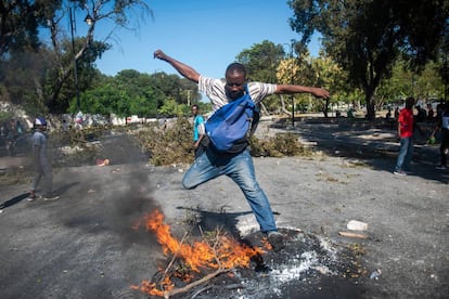 Un hombre corre durante unas protestas convocadas por la oposición para forzar la renuncia del presidente de Haiti.