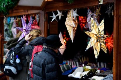 Un grupo de gente mira los productos a la venta en uno de los puestos del mercado navideño de Breitscheidplatz en Berín.