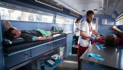 Dos hombres donando sangre este verano. 