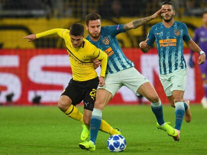 El centrocampista del Atlético, Saúl Ñíguez y  el jugador del Borussia Christian Pulisic, luchan por hacerse con la posesión del esférico.