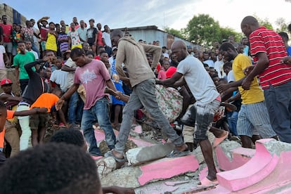 People carry an injured person away from a home that collapsed due to an earthquake in Jeremie, Haiti