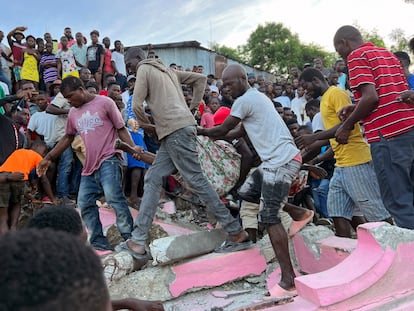 People carry an injured person away from a home that collapsed due to an earthquake in Jeremie, Haiti, on June 6, 2023.