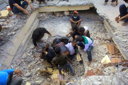 Varias personas durante los trabajos de rescate entre los escombros de un edificio en Pidie Jaya (Indonesia).