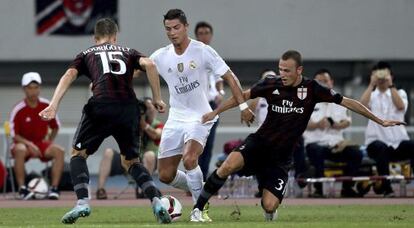 Cristiano Ronaldo lucha por el bal&oacute;n con dos jugadores del Milan