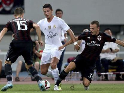 Cristiano Ronaldo lucha por el bal&oacute;n con dos jugadores del Milan