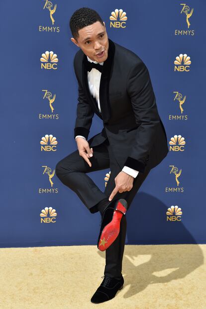 Trevor Noah, conductor del late night The Daily Show, con traje de Musika Frère, muestra la suela de su zapato customizado de Louboutin a los fotógrafos de la alfombra roja.