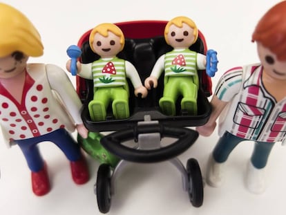 Unos padres múltiples pasean a sus bebés en su carrito gemelar, de Playmobil.