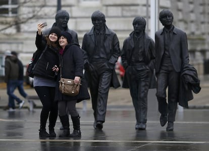 Turistas se hacen un selfi junto a las estatuas de los Beatles en una calle de Liverpool (Reino Unido), en 2016.