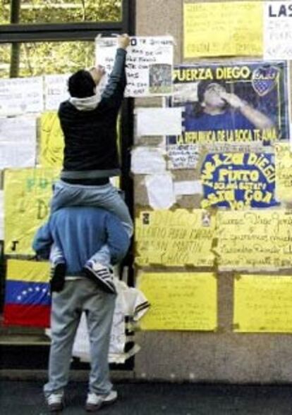 Fans de Maradona, ayer, pegando carteles a las puertas de la clínica.