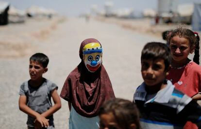 Una niña iraquí con una máscara de payaso se deja fotografiar junto a un grupo de niños en el campo de desplazados de al-Khazer, al este de Mosul (Irak).