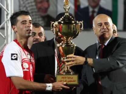 El presidente de la federación palestina,Yibril Rayub, entrega la Copa al capitán del equipo de Hebrón.