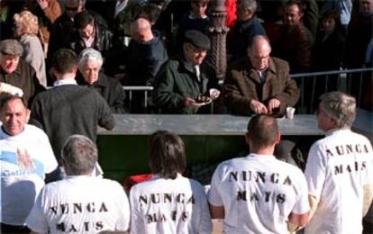 Varios vecinos de Alcalá de Henares recogían un plato de mejillones en la plaza de Cervantes.