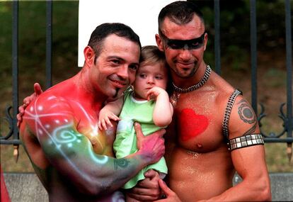 Dos participantes del desfile del Orgullo Gay en Madrid posan con una niña.