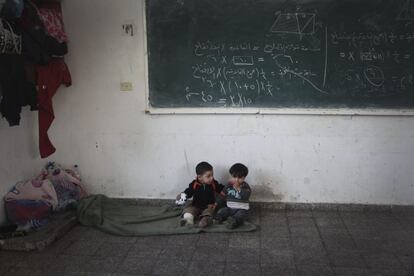 Dos niños palestinos que huyeron de sus casas en Gaza, en un colegio este martes.