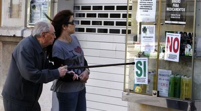 Carteles de protesta en una de las farmacias cerradas por los impagos del Gobierno valenciano