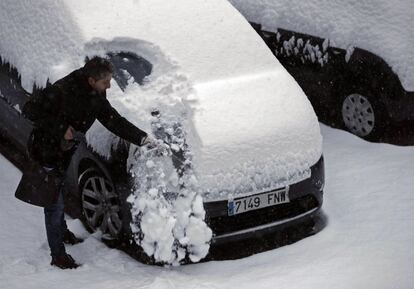 Una persona retira la nieve acumulada en su coche tras las nevadas en Pamplona, el 28 de febrero.