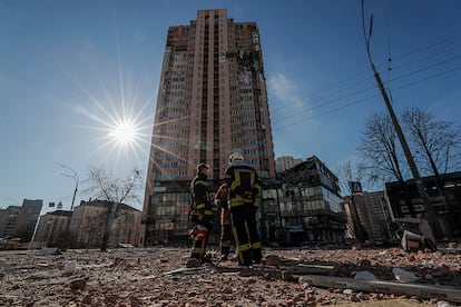 Varios bomberos junto al bloque de viviendas donde impactó un cohete ruso en la céntrica avenida Lobanovsky.