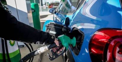 Una persona pone gasolina en una gasolinera.