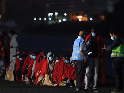 Un grupo de migrantes esperaban el 12 de mayo a ser interrogados por la policía fronteriza española en el puerto de Arguineguín, en Gran Canaria.