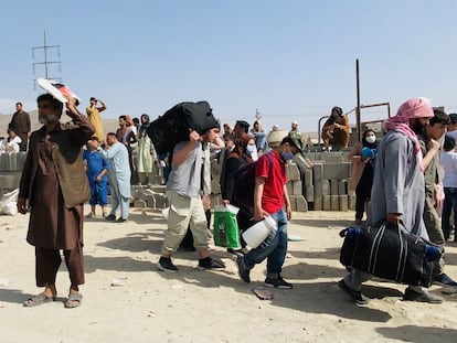 Un grupo de afganos que tratan de huir de Afganistán, ante el aeropuerto de Kabul este jueves.