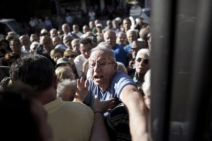 Pensionistas, en una oficina bancaria en Atenas. Desde primeras horas de la mañana, miles de jubilados se han congregado ante el millar de sucursales bancarias abiertas para cobrar un máximo de 120 euros a los que solo disponen de cartilla.