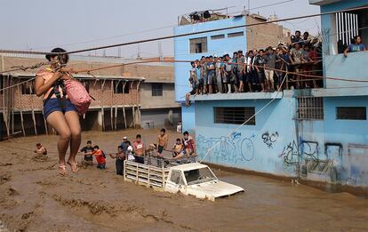 El Servicio Nacional de Meteorología e Hidrología (Senamhi) anunció en su pronóstico más reciente que las precipitaciones se intensificarán durante esta próxima semana. En la imagen, una mujer es evacuada en Lima (Perú), el 17 de marzo de 2017.