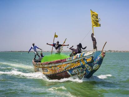 La tripulación de un cayuco de pesca se adentra en el mar tras salir de la desembocadura del río Senegal.
