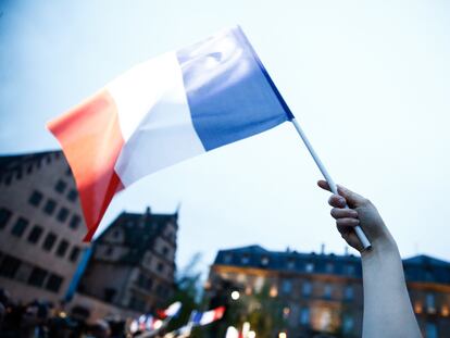 Un manifestante ondea una bandera francesa durante un acto electoral de la campaña presidencial.