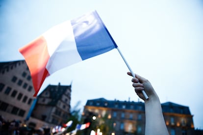 Un manifestante ondea una bandera francesa durante un acto electoral de la campaña presidencial.