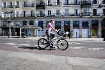 Un usuario de Bicimad pedalea por la Puerta del Sol de Madrid.