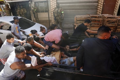 La Policía Civil de Brasil ha confirmado este jueves, 21 de julio, que al menos 18 personas han muerto durante una operación policial contra el crimen organizado en la favela Alemão en el norte de Río de Janeiro. En la fotografía, vecinos ayudan a un hombre herido.